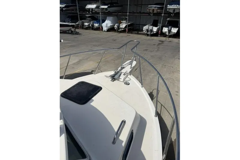 Slide: The Image of 2006 Parker 2520 SL Sport Cabin boat bow with railing in storage facility. - 8
