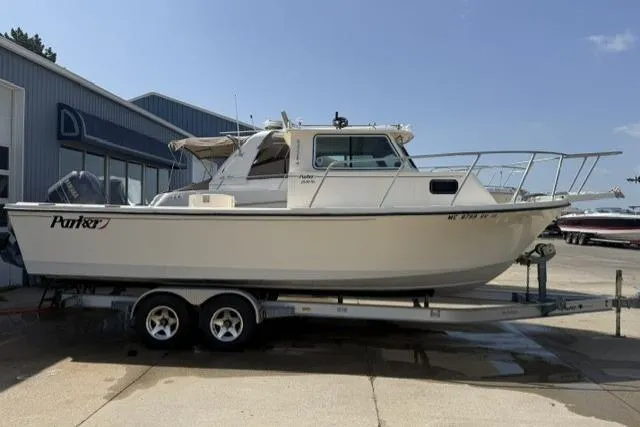 Slide: The Image of 2006 Parker 2520 SL Sport Cabin boat on trailer, parked outside a building. - 4