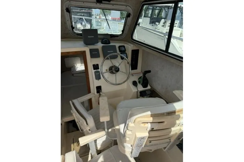 Slide: The Image of Interior of a 2006 Parker 2520 SL Sport Cabin boat, featuring steering wheel and controls. - 14