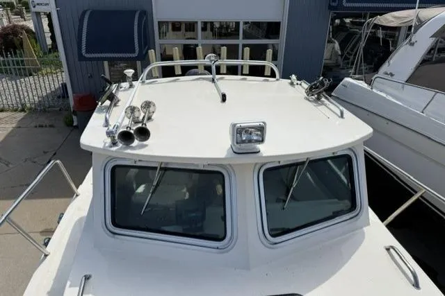 Slide: The Image of 2006 Parker 2520 SL Sport Cabin boat docked, showcasing cabin roof and windows. - 7