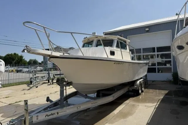 Slide: The Image of 2006 Parker 2520 SL Sport Cabin boat on trailer outside a garage. - 5