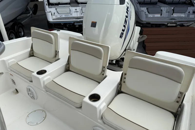 Slide: The Image of 2015 NauticStar 231 Coastal boat seats with Suzuki outboard motor in background. - 10