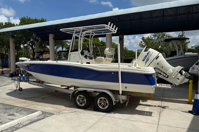 Slide: The Image of 2015 NauticStar 231 Coastal boat on trailer with Suzuki outboard motor. - 2
