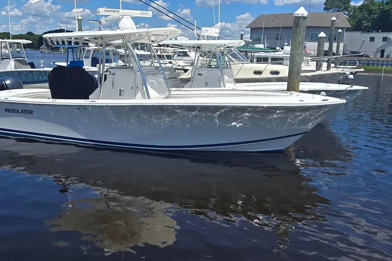 The Image of 2018 Regulator 28 Forward Seating boat docked in a marina under a clear blue sky. - 0