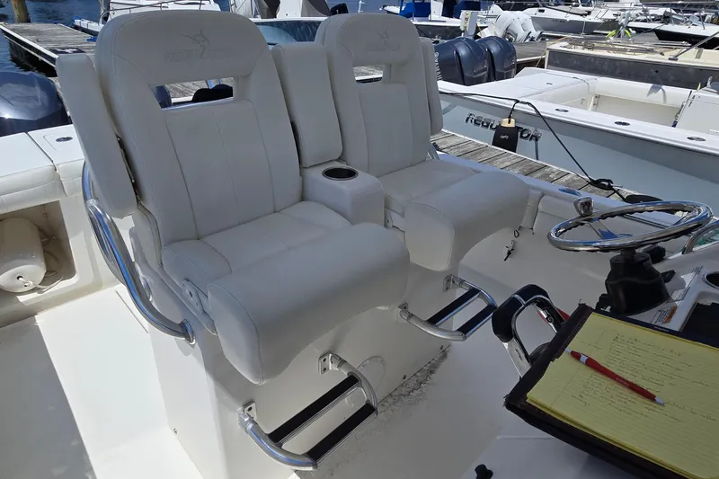 Slide: The Image of 2018 Regulator 28 Forward Seating boat helm with dual white captain chairs and steering wheel. - 33