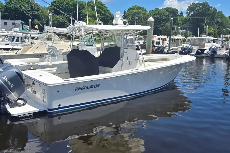 Slide: The Image of 2018 Regulator 28 Forward Seating boat docked in marina with Yamaha engines. - 2