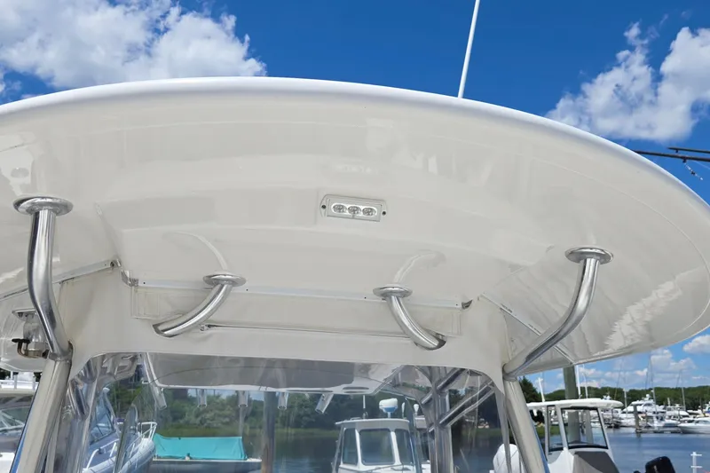 Slide: The Image of 2018 Regulator 28 Forward Seating boat with stainless steel T-top under clear blue sky. - 17