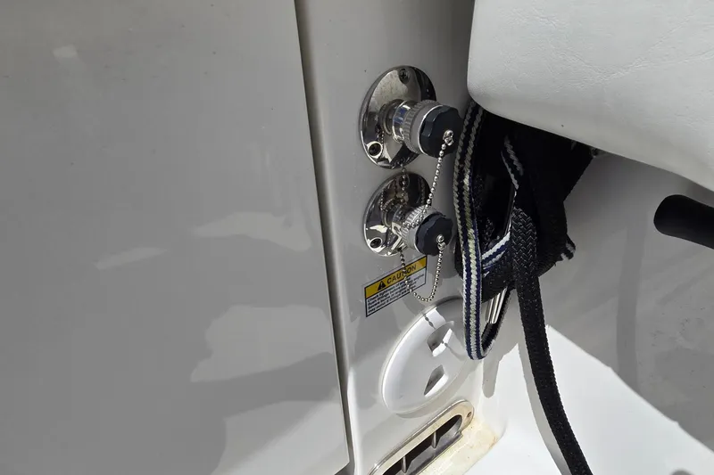 Slide: The Image of 2018 Regulator 28 Forward Seating boat fuel and water inlets with caution label. - 37