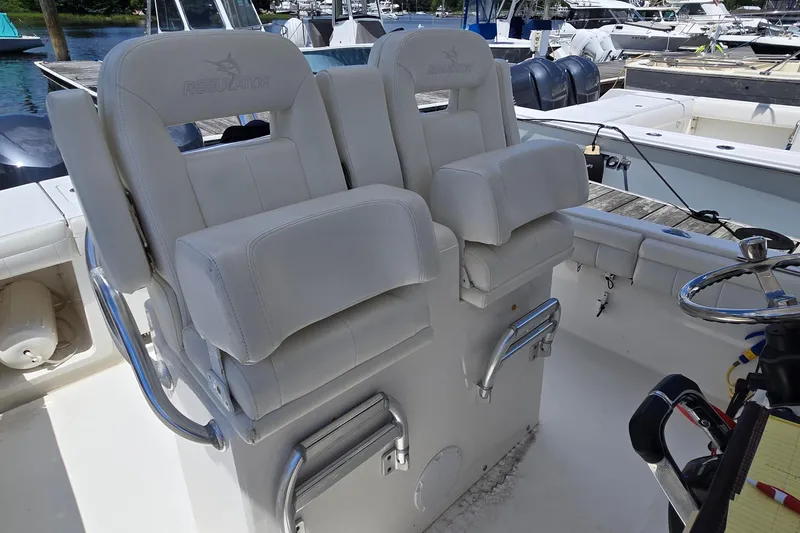 Slide: The Image of 2018 Regulator 28 Forward Seating boat with dual helm seats and steering wheel. - 32