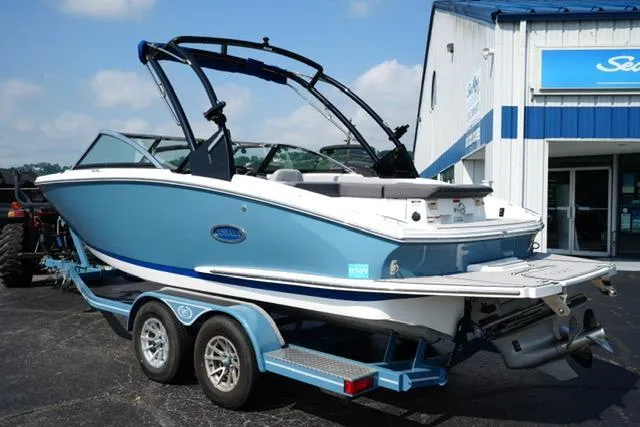 Slide: The Image of 2024 Cobalt CS22 boat on trailer, blue and white, parked outside dealership. - 7
