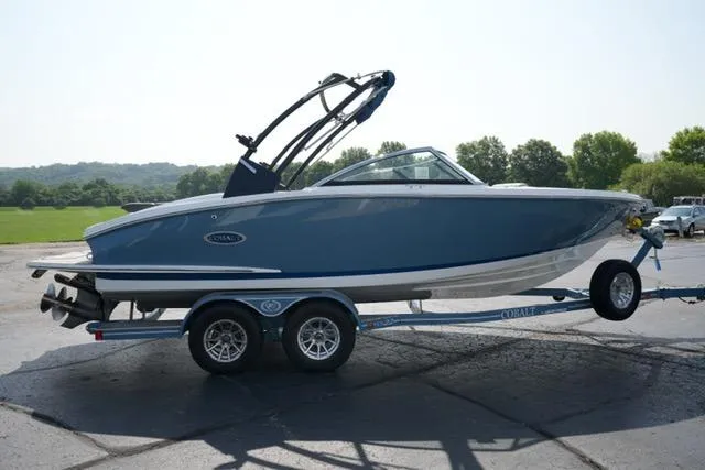 Slide: The Image of 2024 Cobalt CS22 boat on trailer, blue and white design, parked outdoors. - 4