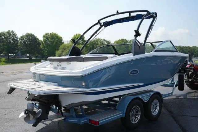 Slide: The Image of 2024 Cobalt CS22 boat on trailer, blue and white design, parked outdoors. - 5