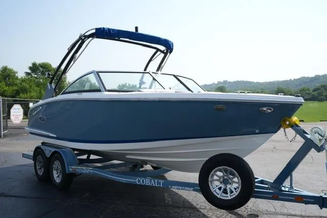 Slide: The Image of 2024 Cobalt CS22 boat on trailer, blue hull, parked outdoors on a sunny day. - 3