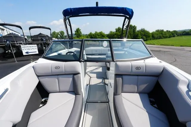 Slide: The Image of 2024 Cobalt CS22 boat interior with gray seating and blue canopy, parked outdoors. - 11