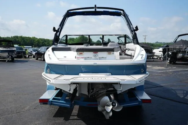 Slide: The Image of 2024 Cobalt CS22 boat, rear view, parked on a trailer in a marina. - 6