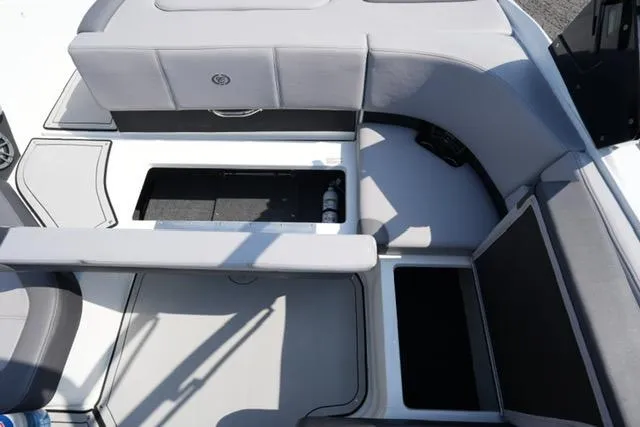 Slide: The Image of 2024 Cobalt CS22 boat interior with open storage compartments and gray seating. - 16