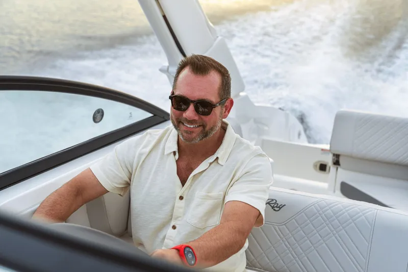 Slide: The Image of A man is steering a Sea Ray SDX 250 Outboard boat on the water. - 28