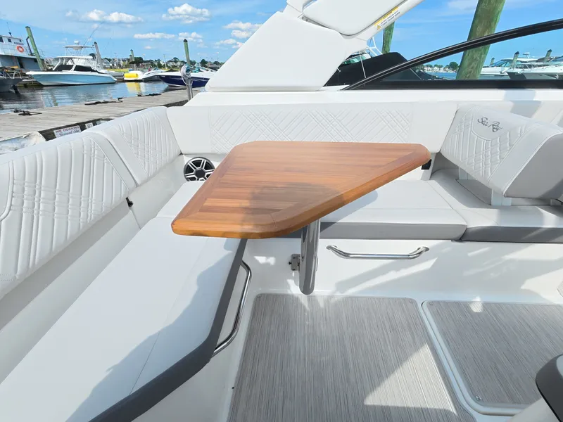 Slide: The Image of The image shows the cockpit of a 2026 Sea Ray SDX 250 Outboard with a sleek wooden table. - 15