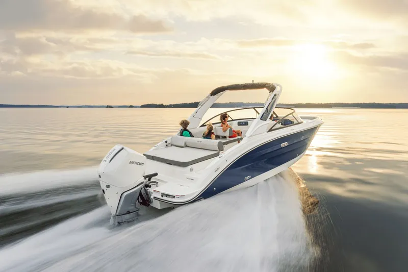 Slide: The Image of A Sea Ray SDX 250 Outboard boat cruising on calm water at sunset. Two people are on board. - 3