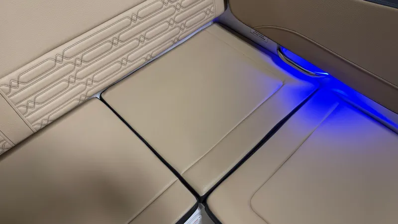 Slide: The Image of The seating area of a Sea Ray SPX 210 with beige upholstery and blue LED lighting. - 29
