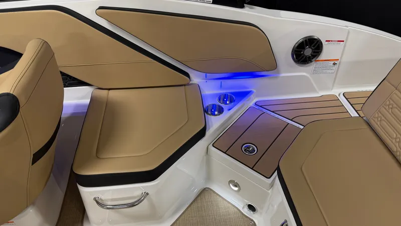 Slide: The Image of Interior of a Sea Ray SPX 210 boat with beige upholstery and blue LED lighting. - 19