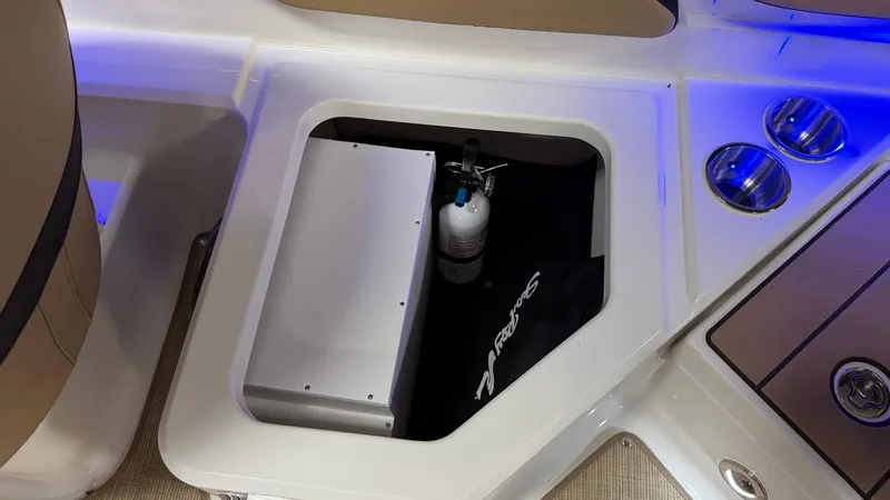 Slide: The Image of A storage compartment in the Sea Ray SPX 210 boat with a fire extinguisher and cup holders. - 21