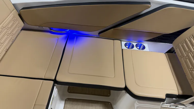 Slide: The Image of Interior of a Sea Ray SPX 210 boat with beige upholstery and blue LED lighting. - 36