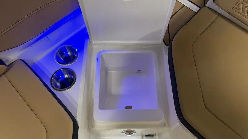Slide: The Image of An open storage compartment on a Sea Ray SPX 210 boat, surrounded by cushioned seats and blue lighting. - 25