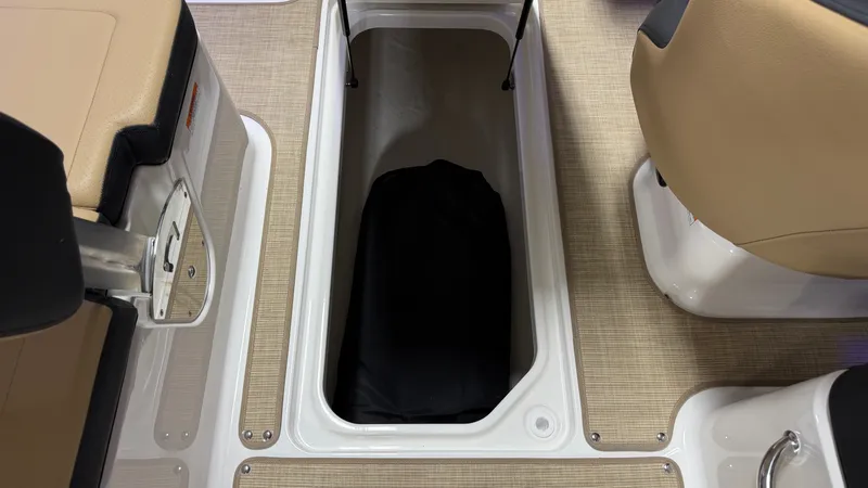 Slide: The Image of An open storage compartment on a Sea Ray SPX 210 boat with beige carpeting. - 49