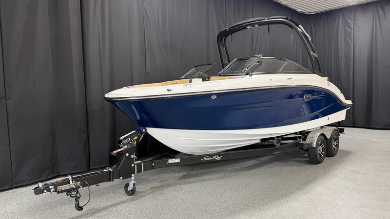 Slide: The Image of A 2027 Sea Ray SPX 210 boat on a trailer in an indoor setting. - 2