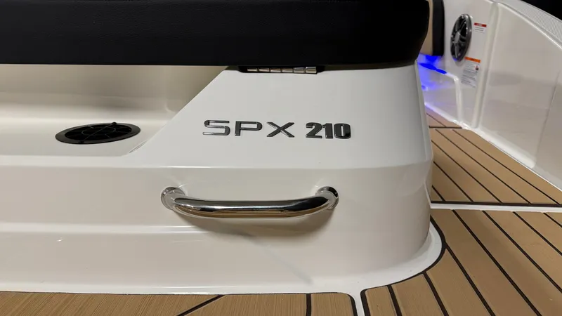 Slide: The Image of Close-up of the Sea Ray SPX 210 boat with sleek white hull and wood flooring. - 13