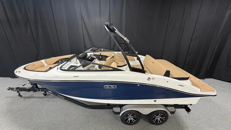 Slide: The Image of 2027 Sea Ray SPX 210 with a blue hull and beige interior on a trailer. - 1