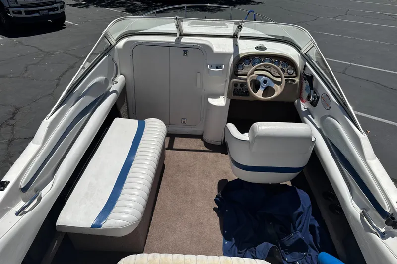 Slide: The Image of 2002 Chaparral 205 SSe boat interior with steering wheel and seating in a parking lot. - 10