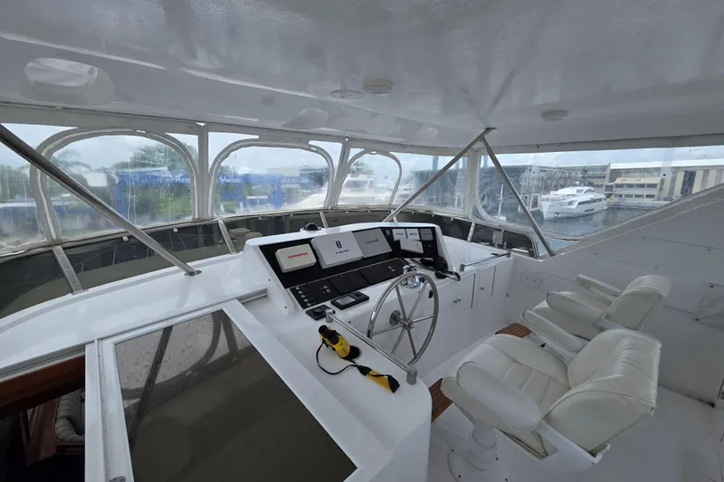 Slide: The Image of Cockpit of 2000 Ocean Alexander 60 Trawler with modern navigation equipment and white seating. - 6
