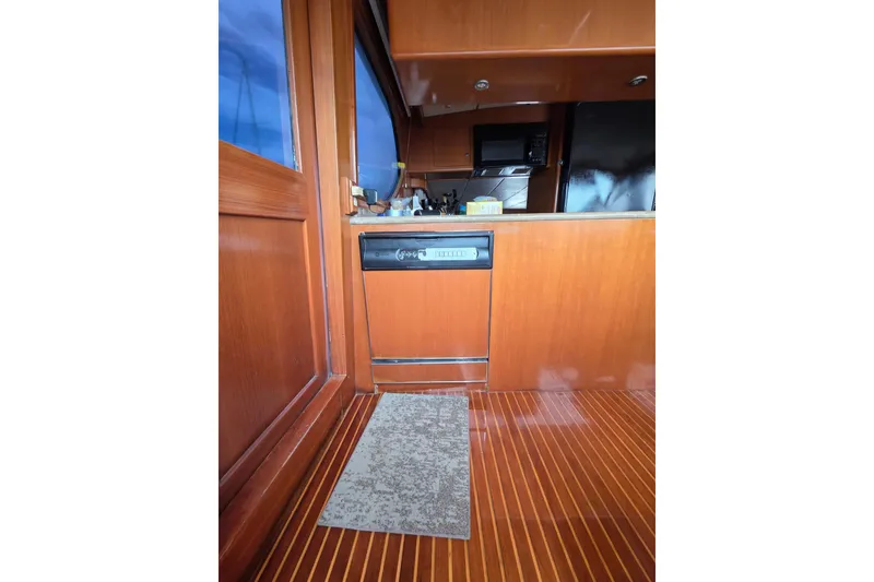 Slide: The Image of Interior of 2000 Ocean Alexander 60 Trawler with wooden cabinetry and flooring. - 17