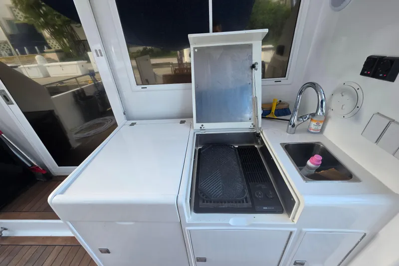 Slide: The Image of Outdoor kitchen area on a 2000 Ocean Alexander 60 Trawler yacht, featuring a grill and sink. - 10