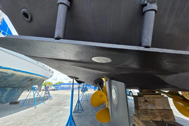 Slide: The Image of Bottom view of a 2000 Ocean Alexander 60 Trawler on dry dock, showcasing propellers and hull. - 34