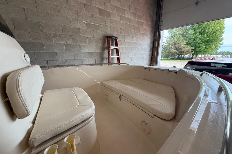 Slide: The Image of 2025 Grady-White Fisherman 180 boat interior with cushioned seating in a garage setting. - 6