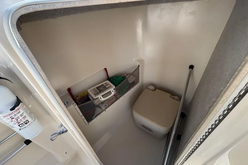 Slide: The Image of 2004 Scout 222 Dorado boat interior storage with portable toilet and safety equipment. - 15
