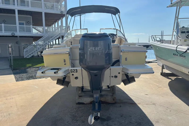 Slide: The Image of 2004 Scout 222 Dorado boat with 200 horsepower engine, docked near a marina. - 3