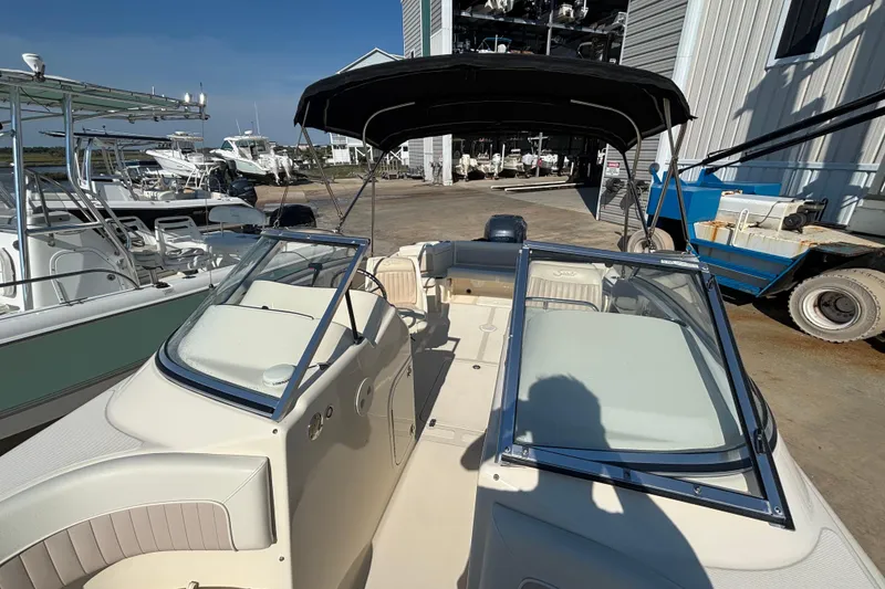 Slide: The Image of 2004 Scout 222 Dorado boat with canopy, docked among other vessels. - 6