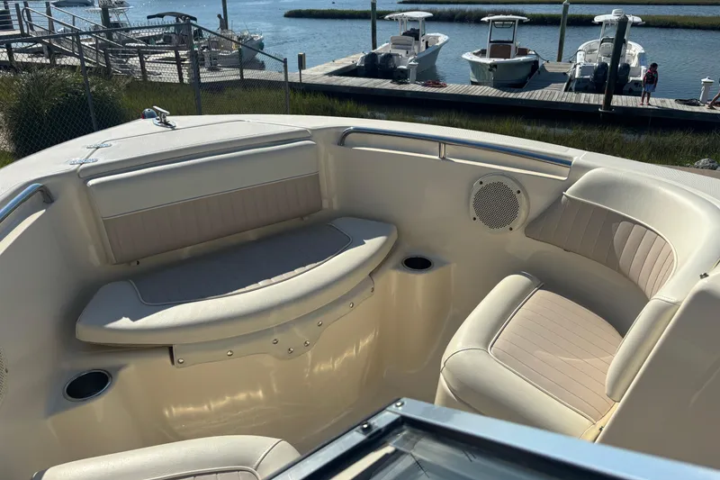 Slide: The Image of 2004 Scout 222 Dorado boat interior with cushioned seating and waterfront view. - 14
