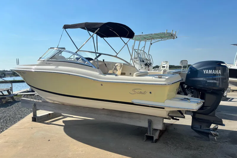Slide: The Image of 2004 Scout 222 Dorado boat with Yamaha outboard motor on display by the water. - 1
