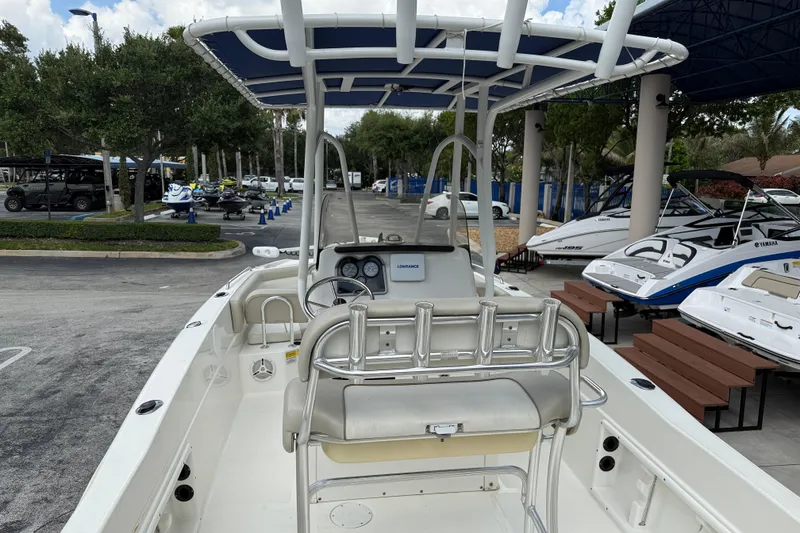Slide: The Image of 2015 NauticStar 231 Coastal boat with T-top, parked in a marina with other boats. - 9