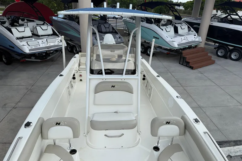 Slide: The Image of 2015 NauticStar 231 Coastal boat displayed in a showroom with other boats. - 15