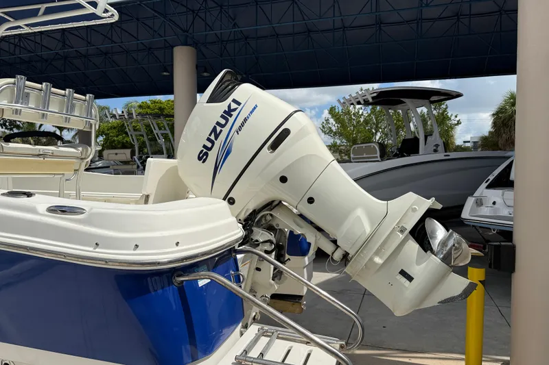 Slide: The Image of 2015 NauticStar 231 Coastal boat with Suzuki outboard motor in a marina setting. - 7