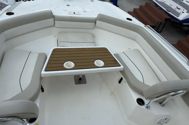 Slide: The Image of 2015 NauticStar 231 Coastal boat interior with seating and table setup. - 16