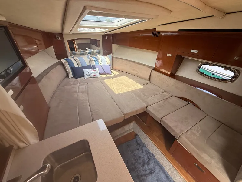Slide: The Image of Interior of a 2010 Sea Ray Sundancer 310 with cozy seating and a small sink. - 34