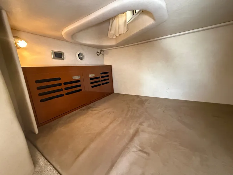 Slide: The Image of Interior of a 2010 Sea Ray Sundancer 310 with carpeted floor and wooden accents. - 37