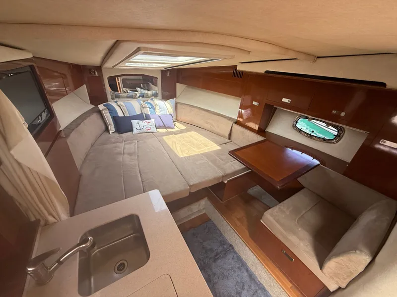 Slide: The Image of Interior of a 2010 Sea Ray Sundancer 310 with a cozy seating area and table. - 36